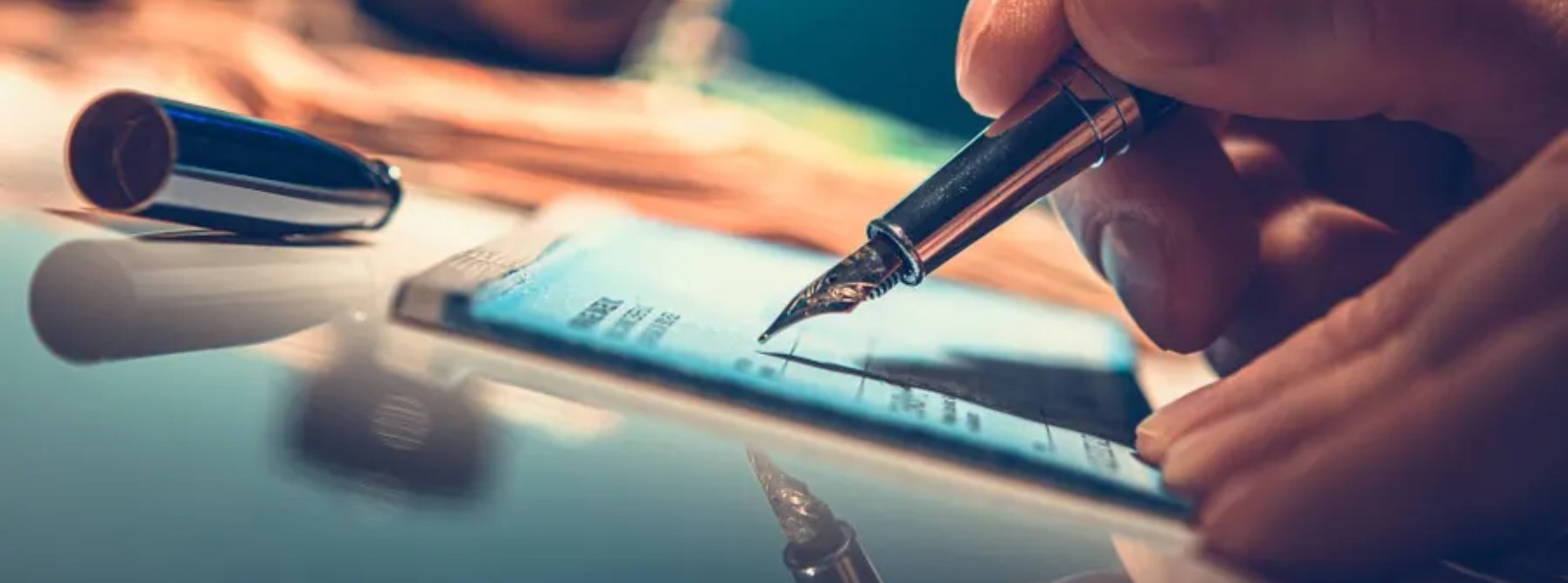 a person writing on a paper check
