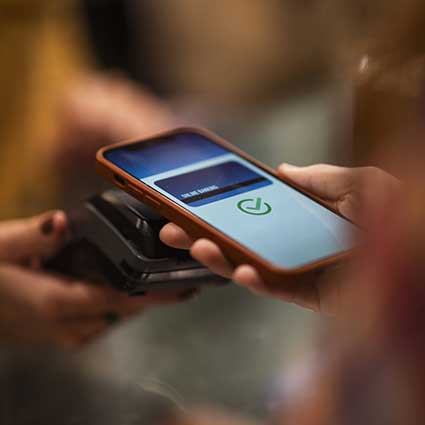 Person using their smartphone to make a payment in a small business