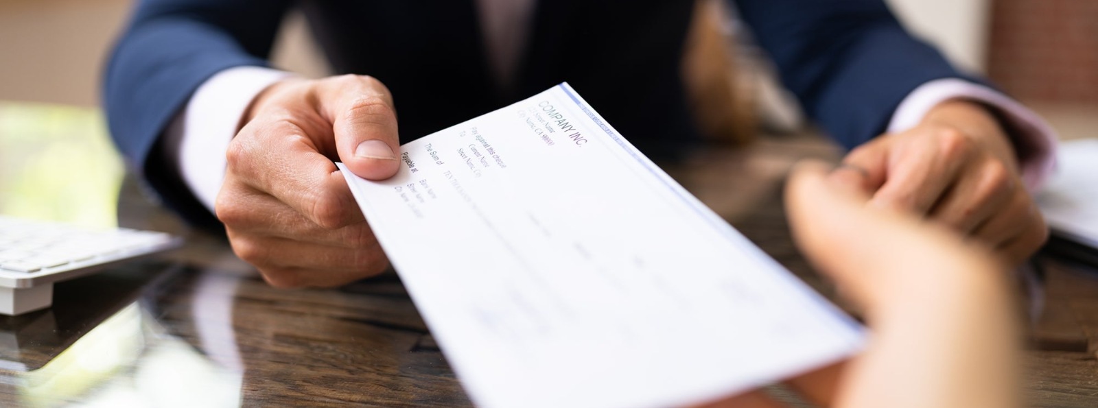 a person handing a cashier's check to a person
