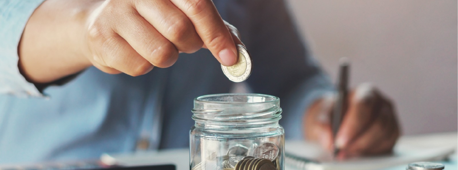 a person putting coins in a jar